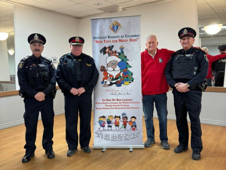 4 men, 3 police, next to a banner