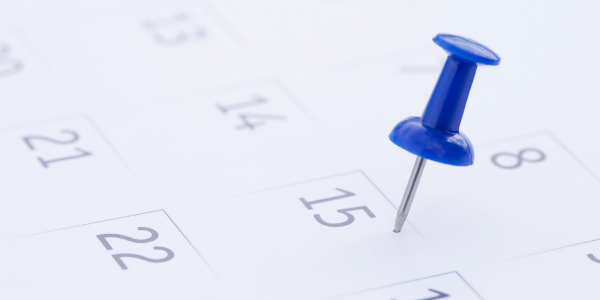 Grand Knight Message close of up a calendar page with a blue push pin sticking out of it.