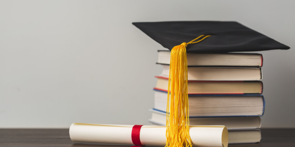 Ontario State Bursary grad cap and diploma on top of books
